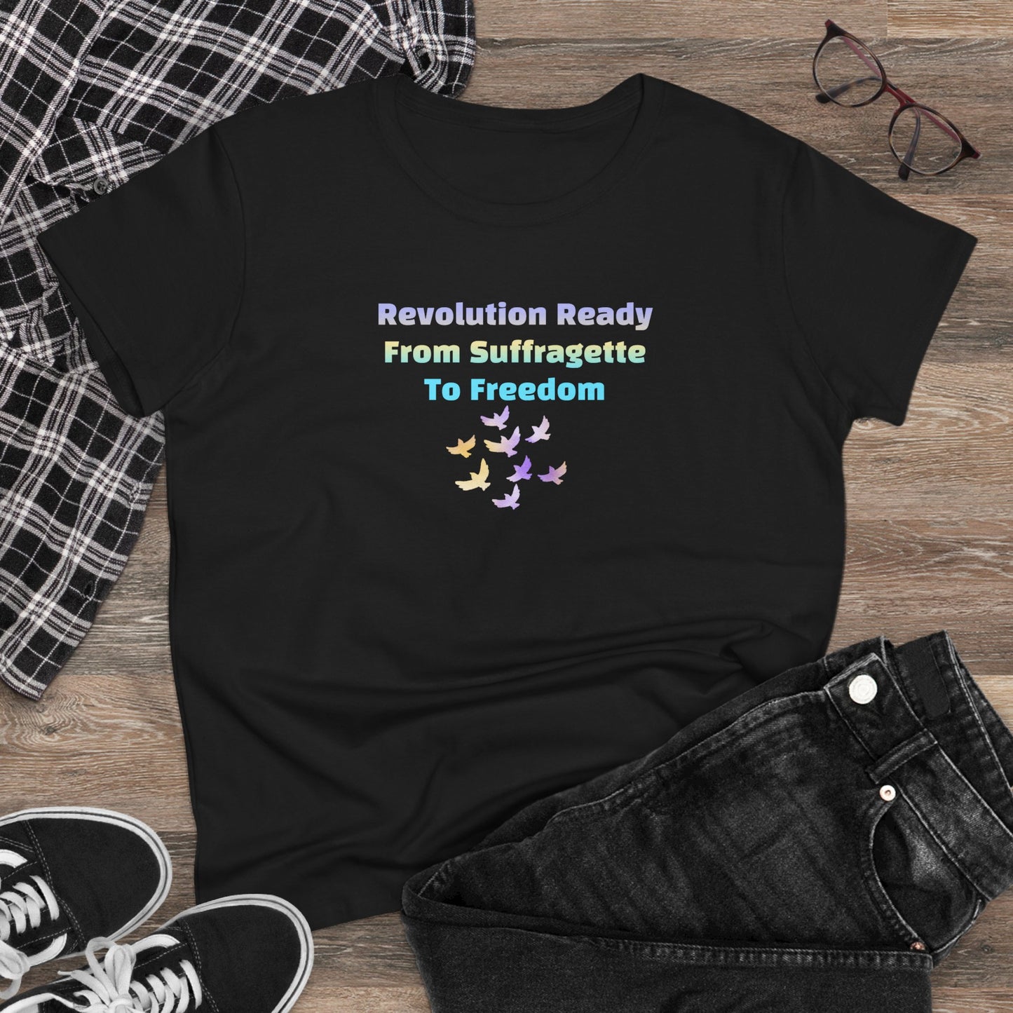 Black t-shirt with colorful text and butterfly design on a wooden surface with jeans and sneakers.