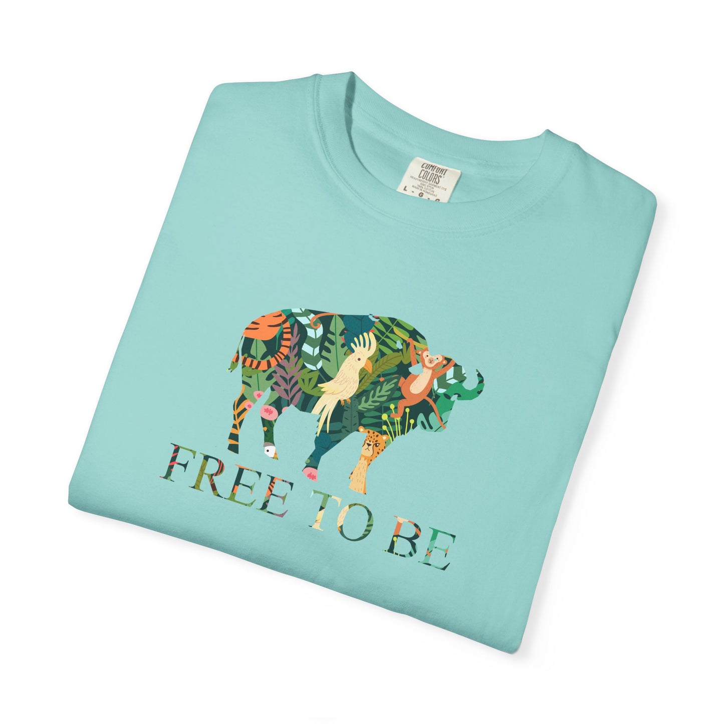 Folded mint green t-shirt with a colorful animal design and 'FREE TO BE' text on a white background