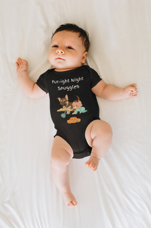Baby wearing a black onesie with graphics and text, lying on a white surface.