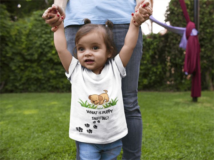 Child wearing a shirt with a cartoon dog and text, standing outdoors.