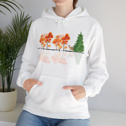 White hoodie with nature-themed design featuring trees and a deer, worn by a person.