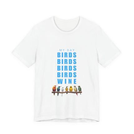 A white short-sleeve crewneck t-shirt featuring a graphic print on the front with the text 'MY DAY BIRDS BIRDS BIRDS BIRDS WINE' in blue, above a row of 7 colorful birds perched on a branch.
