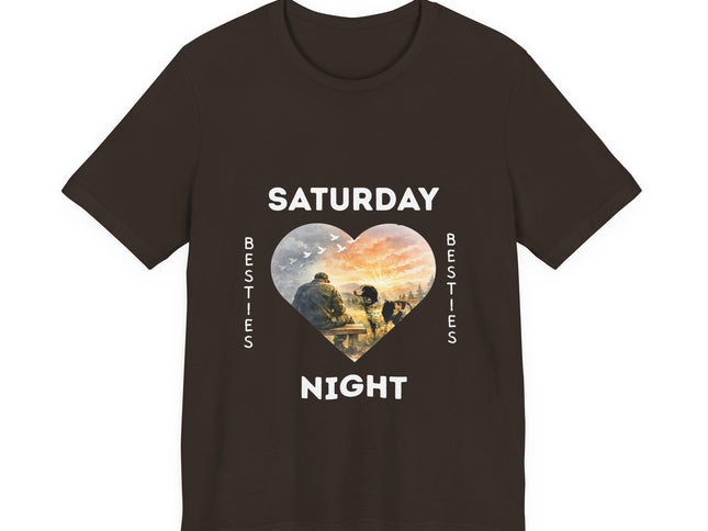 A dark brown short-sleeve t-shirt with a graphic on the front that reads 'SATURDAY NIGHT Besties' in white text, surrounding a heart-shaped scenic photo print of a vet who is sitting alone on a bench. His loving dog is gazing at him. 