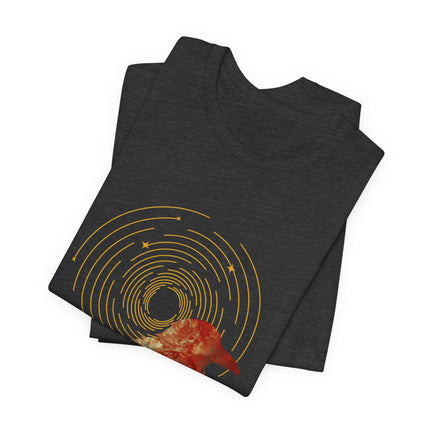 Raven dreamcatcher boho graphic with golden celestial rings and teal textured artwork on a folded black t-shirt.