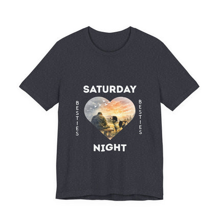 A dark heather gray short-sleeve t-shirt with a  graphic on the front that reads 'SATURDAY NIGHT Besties' in white text, surrounding a heart-shaped scenic photo print of a vet who is sitting alone on a bench. His loving dog is gazing at him. 