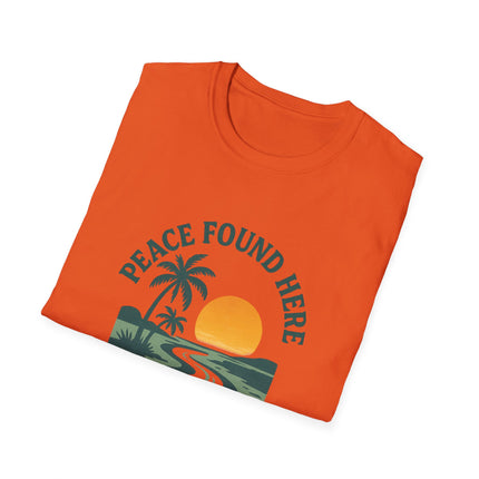 Folded orange t-shirt with 'Peace Found Here' graphic design on a white background