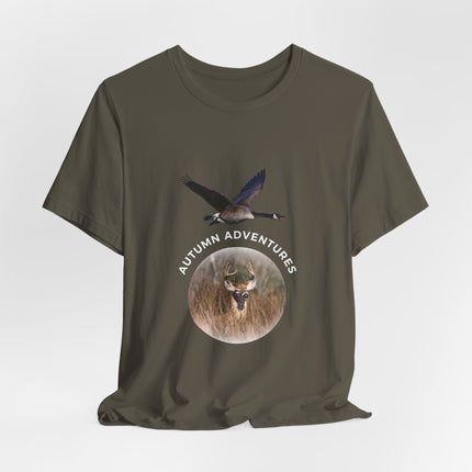 An olive green short-sleeve t-shirt with a graphic print on the front showing a flying goose above a deer head inside a circle with the text 'AUTUMN ADVENTURES'.