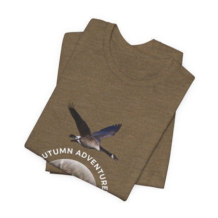 A folded heather brown t-shirt featuring a graphic of a flying Canada goose and the text 'AUTUMN ADVENTURE' in white, displayed on a clean white background.