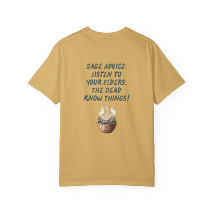 A mustard yellow t-shirt shown from the back, featuring a dark teal graphic text that reads 'SAGE ADVICE: LISTEN TO YOUR ELDERS. THE DEAD KNOW THINGS!' above a small illustration of a cauldron containing sage, with white steam or smoke.