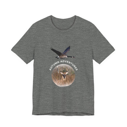 A heather gray short-sleeve t-shirt with a graphic on the front showing a flying goose above a circular deer head in a field, with the text 'AUTUMN ADVENTURES' curved around the circle.