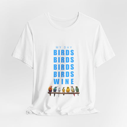 A white short-sleeve crewneck t-shirt with a graphic print on the front. The graphic features the text 'MY DAY BIRDS BIRDS BIRDS BIRDS WINE' in blue, with 7 colorful birds perched on a brown branch at the bottom.