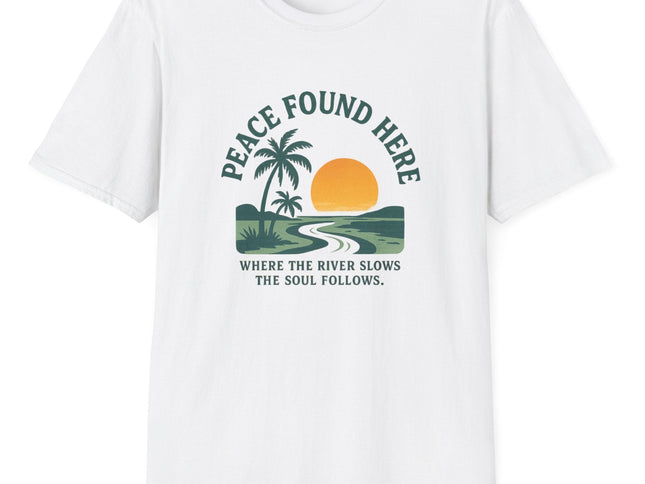 White t-shirt with a graphic design featuring a palm tree, sun, and river, with text 'Peace Found Here'.