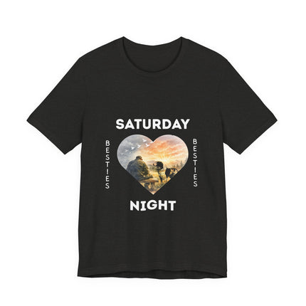 A black short-sleeve t-shirt with a graphic on the front that reads 'SATURDAY NIGHT Besties' in white text, surrounding a heart-shaped scenic photo print of a vet who is sitting alone on a bench. His loving dog is gazing at him. 
