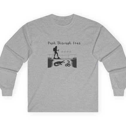 Gray long sleeved tee with black graphic showing hiker going over bridge with alligator and snake. Text states "Push through Fear."