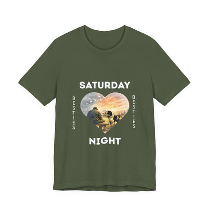 A ilive green short-sleeve t-shirt with a graphic on the front that reads 'SATURDAY NIGHT Besties' in white text, surrounding a heart-shaped scenic photo print of a vet who is sitting alone on a bench. His loving dog is gazing at him. 