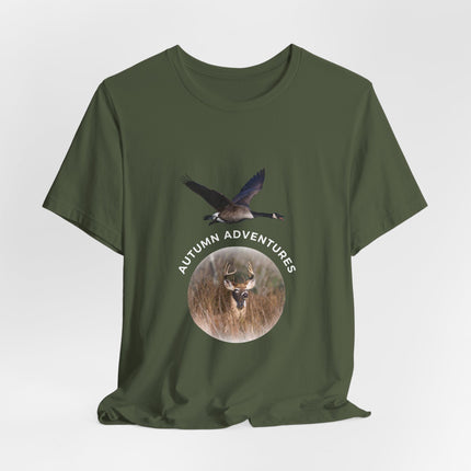 An olive green short-sleeve t-shirt with a graphic print on the front showing a flying goose above a circular deer head with the text 'AUTUMN ADVENTURES'.