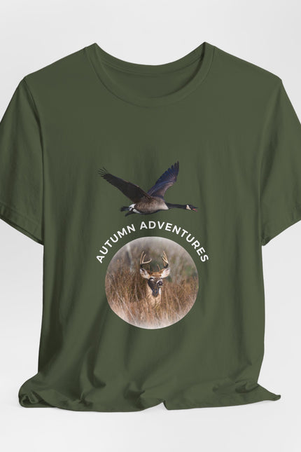 An olive green short-sleeve t-shirt with a graphic print on the front showing a flying goose above a circular deer head with the text 'AUTUMN ADVENTURES'.