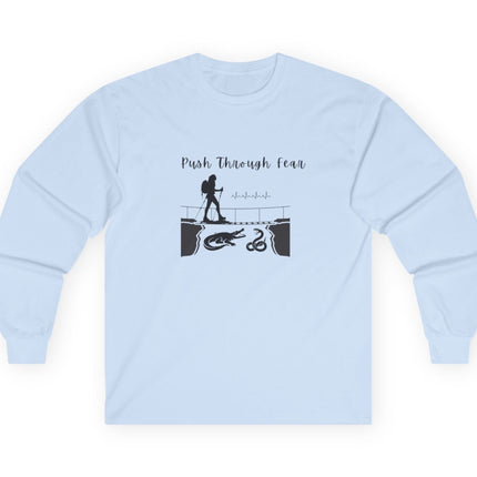 Light Blue long sleeved tee with black graphic showing hiker going over bridge with alligator and snake. Text states "Push through Fear."