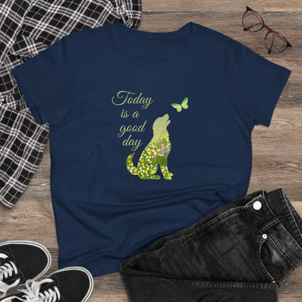 Navy blue t-shirt with a green dog and butterfly graphic and text 'Today is a good day' on a wooden surface with casual items.