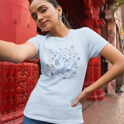 Woman wearing a light blue t-shirt with a floral design in front of red architectural elements.