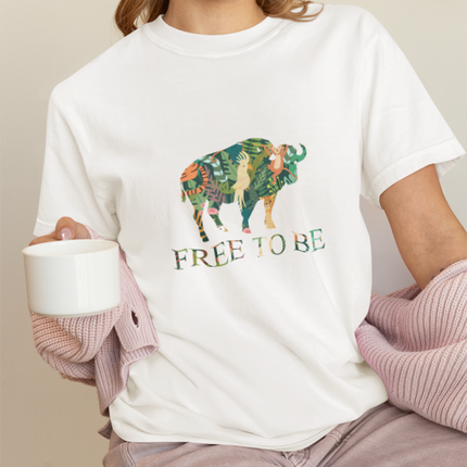 Person wearing a white t-shirt with a colorful buffalo graphic and 'FREE TO BE' text.