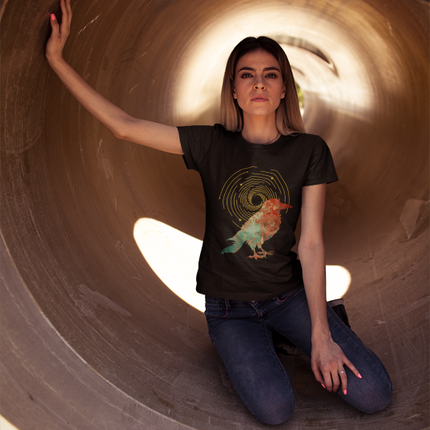 Woman wearing a black t-shirt with a graphic design, sitting inside a large cylindrical concrete structure.