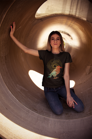 Woman wearing a black t-shirt with a graphic design, sitting inside a large cylindrical concrete structure.