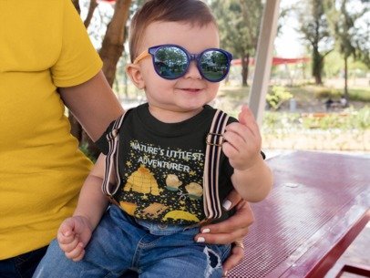 Child wearing sunglasses and a t-shirt with nature-themed graphics outdoors