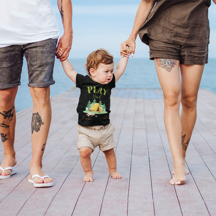 Two adults walking with a child wearing a black t-shirt.