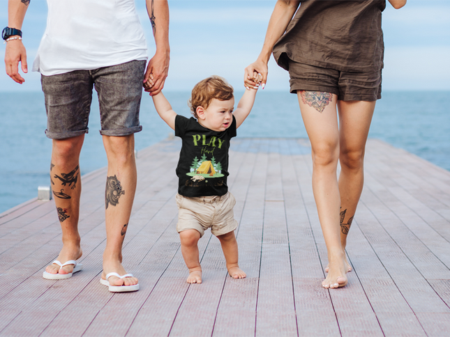 Two adults walking with a child wearing a black t-shirt.