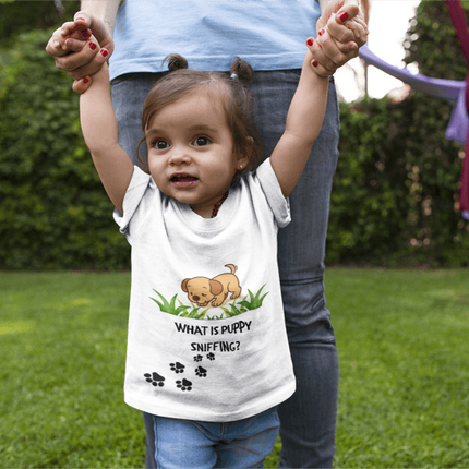 Child wearing a shirt with a cartoon dog and text, standing outdoors.
