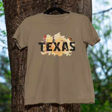 Green t-shirt with 'TEXAS' printed on it hanging on a tree