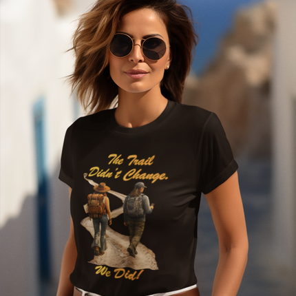 Woman wearing a black t-shirt with graphic design and text, standing outdoors.