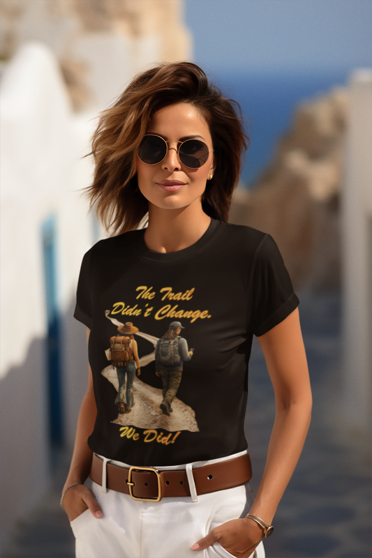 Woman wearing a black t-shirt with graphic design and text, standing outdoors.